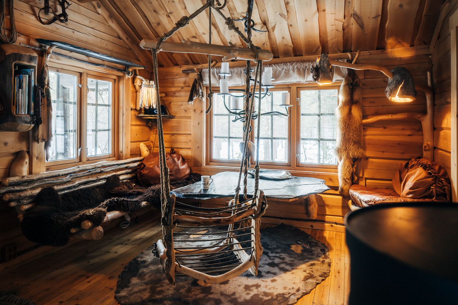 The main room of Biiga with a fireplace and a hanging seat
