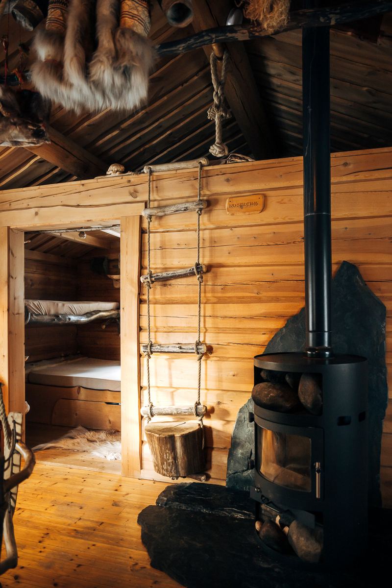 A black iron stove beside the bunk in Biiga