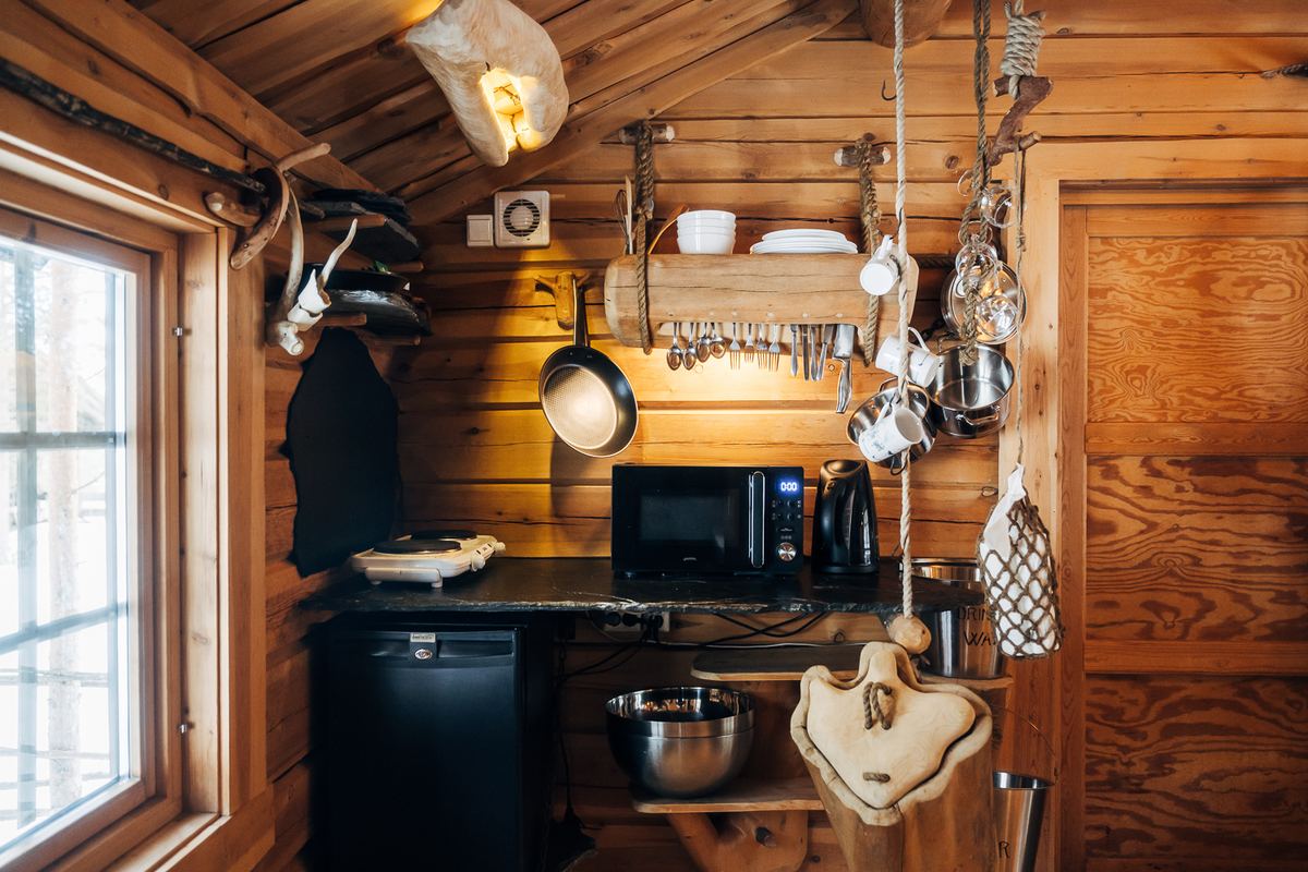 The kitchenette with pans and utensils hung on the wall