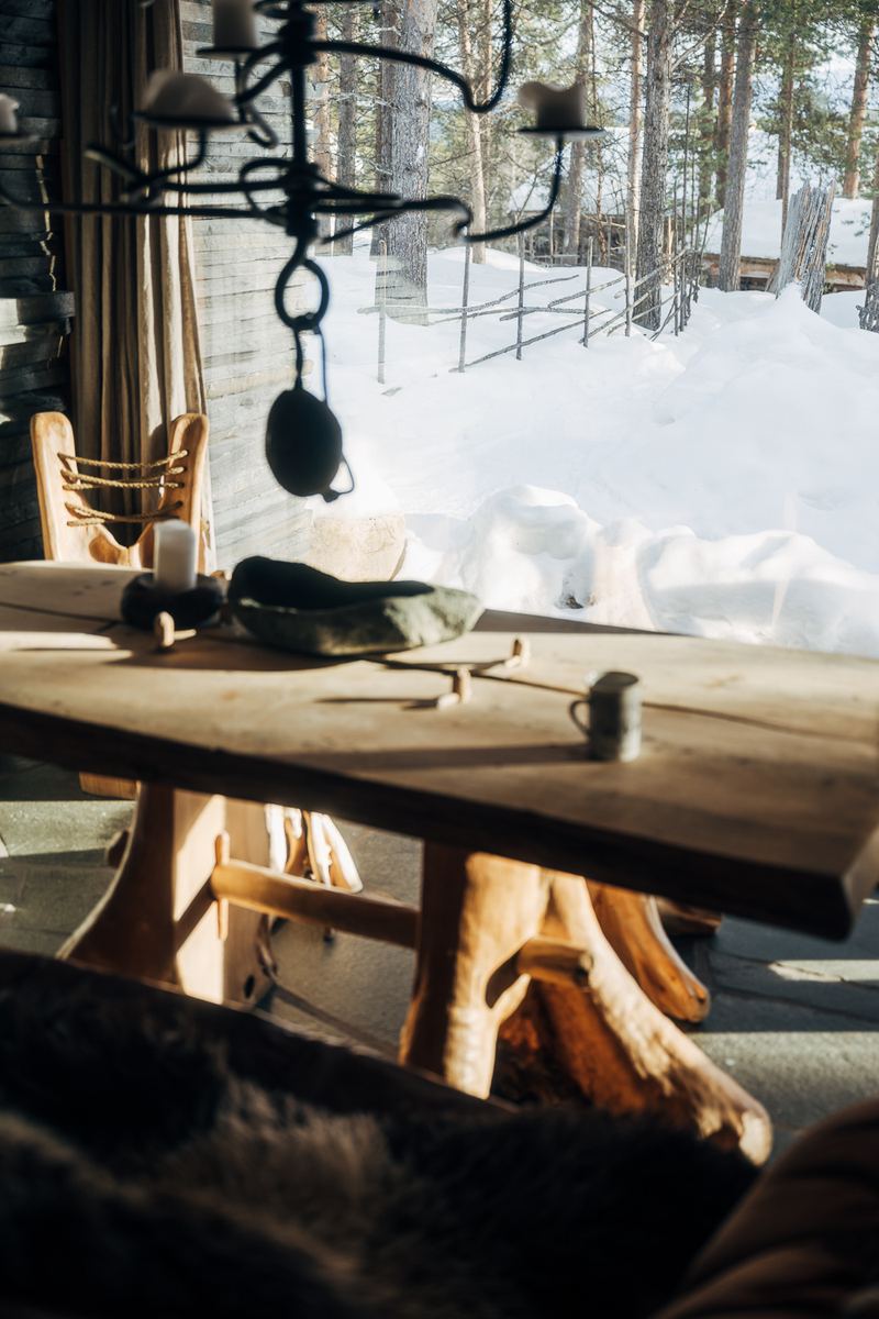 A table of whole timber with a reindeer hide over the bench
