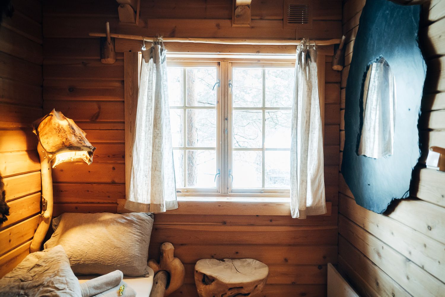 A window seat with white curtains and a sheepskin