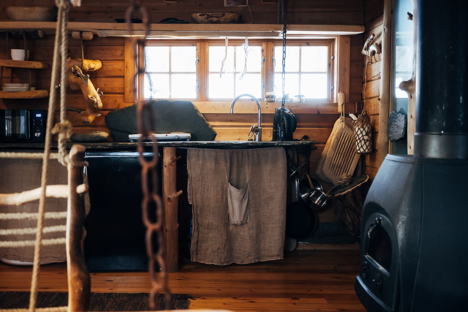 The kitchenette with a sink, kettle and hanging utensils