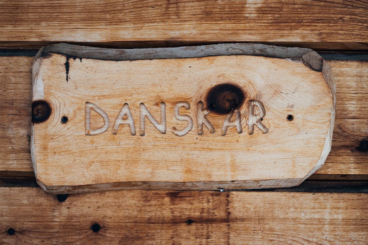 A hand-carved wooden sign reading DANSKAR