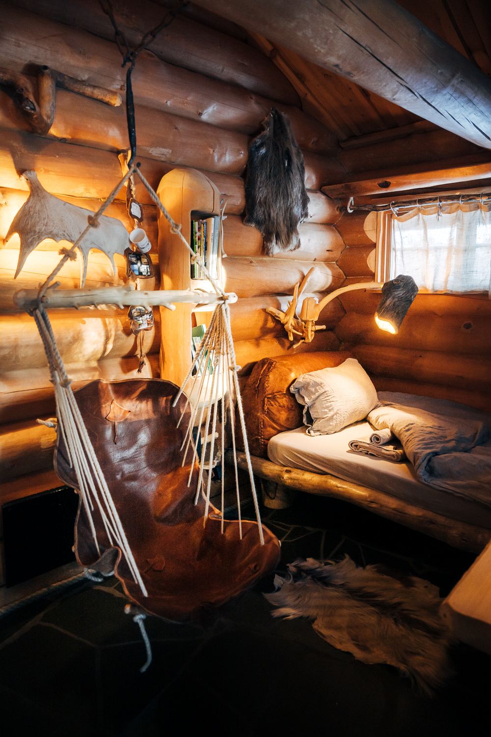 The whole of Latnja in one frame: bed, antlers and lamplight