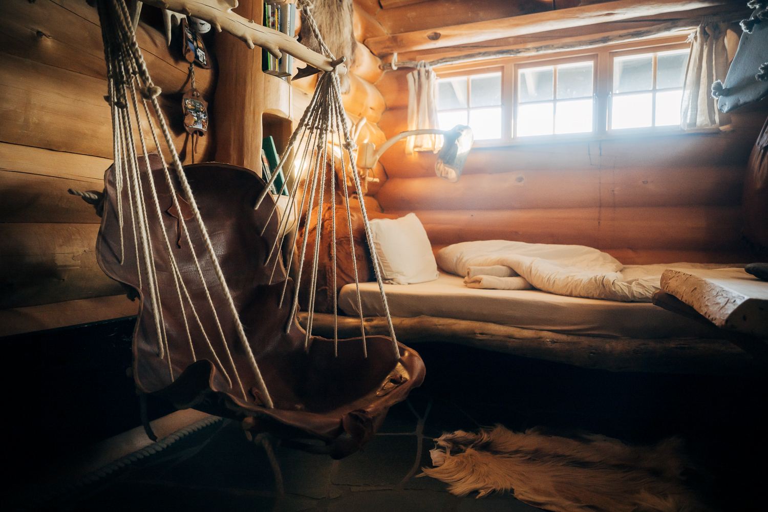 The double bed under the window, lit low