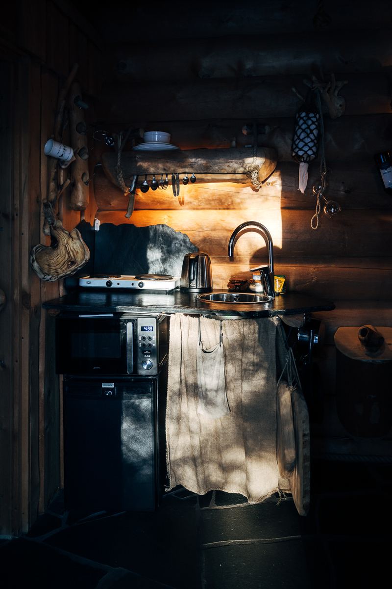 The kitchenette in the corner, lit by the window