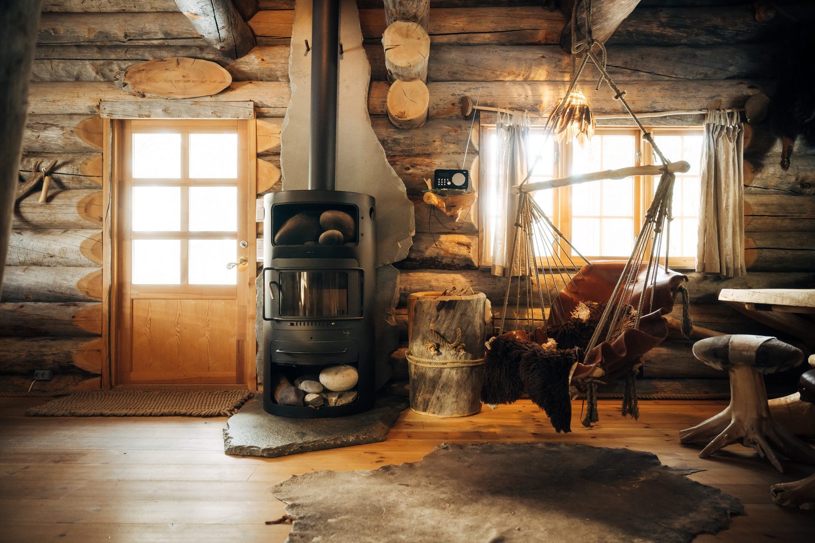 Morning sun across Soarvi's main room: the stove, the door and a hanging seat