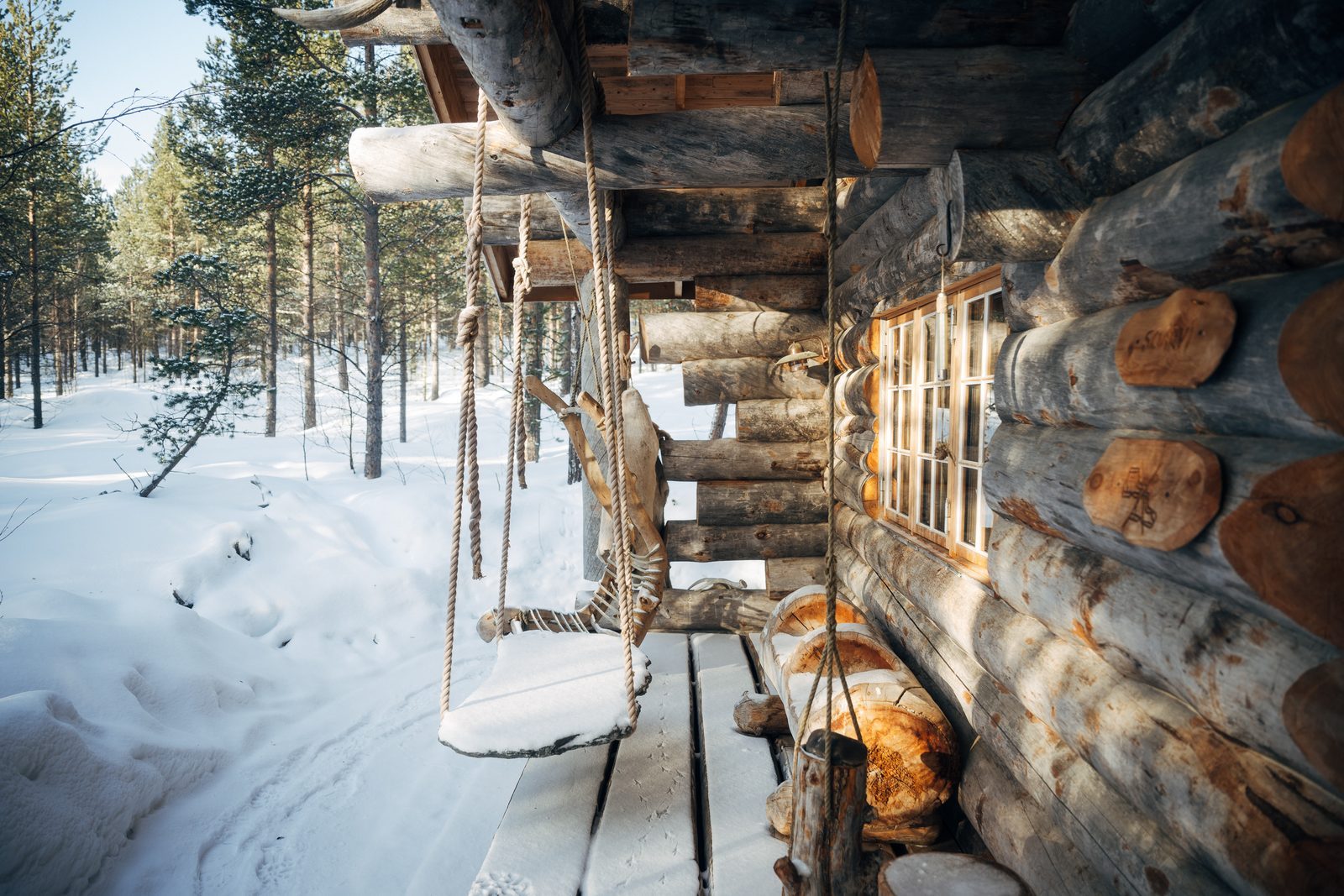 The log wall of Soarvi in winter sun, a bench under the window