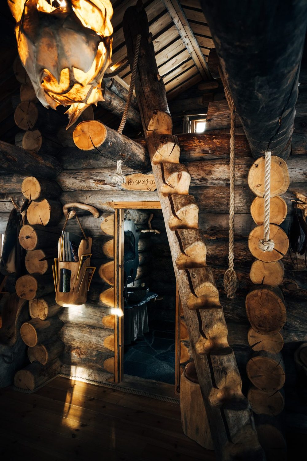 Warm light on the log wall, a mirror and lamp