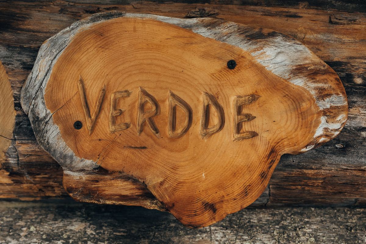 A hand-carved wooden sign reading VERDDE