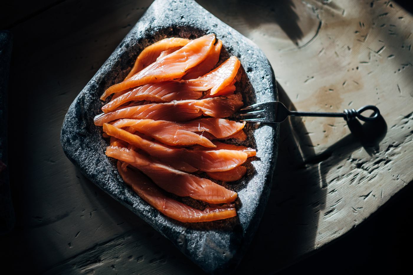 Cured salmon fanned out on a slate plate