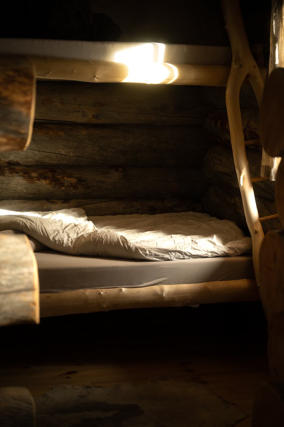 A bunk bed built from pine, warm lamplight