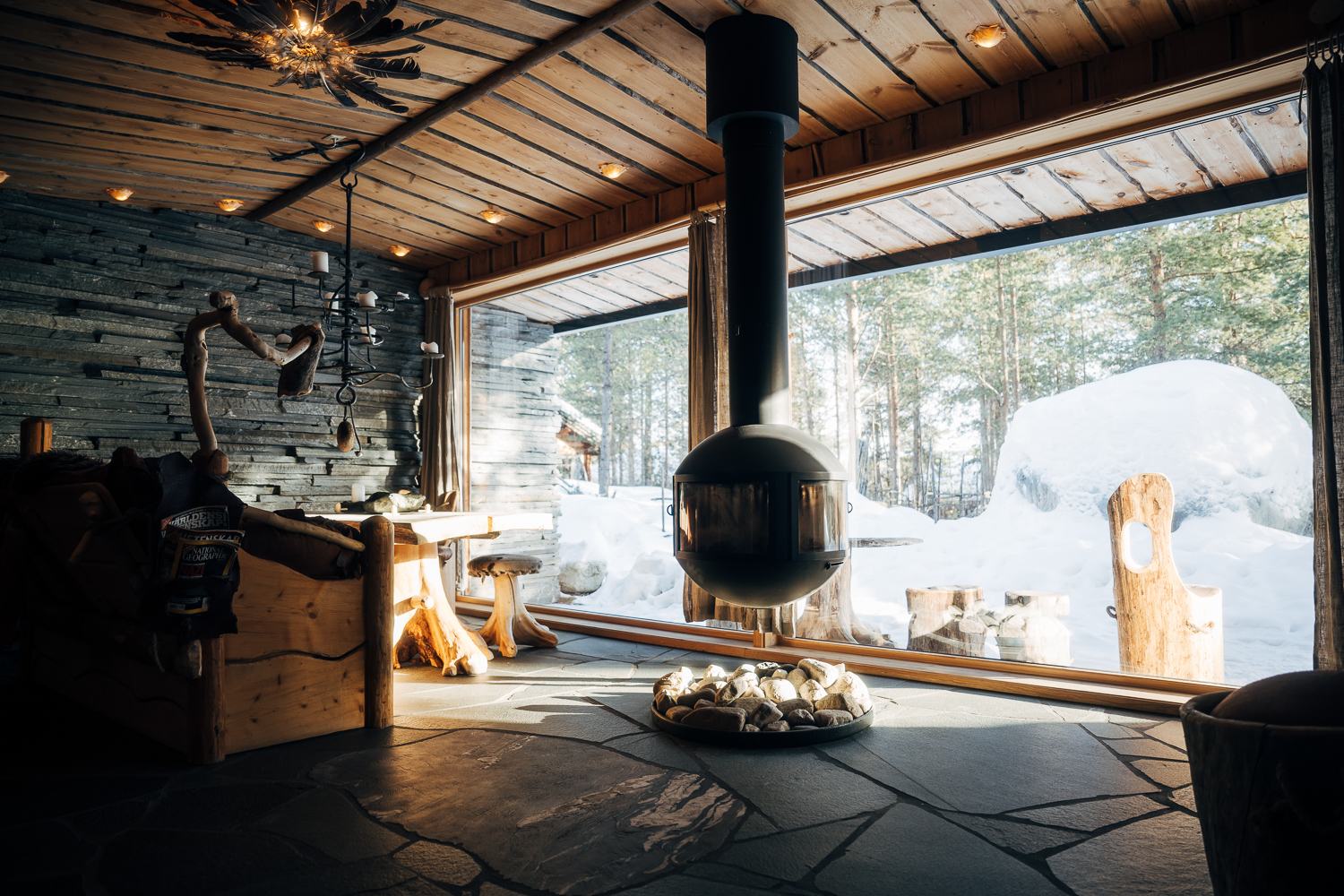 A hanging stove in front of a window looking out over snow